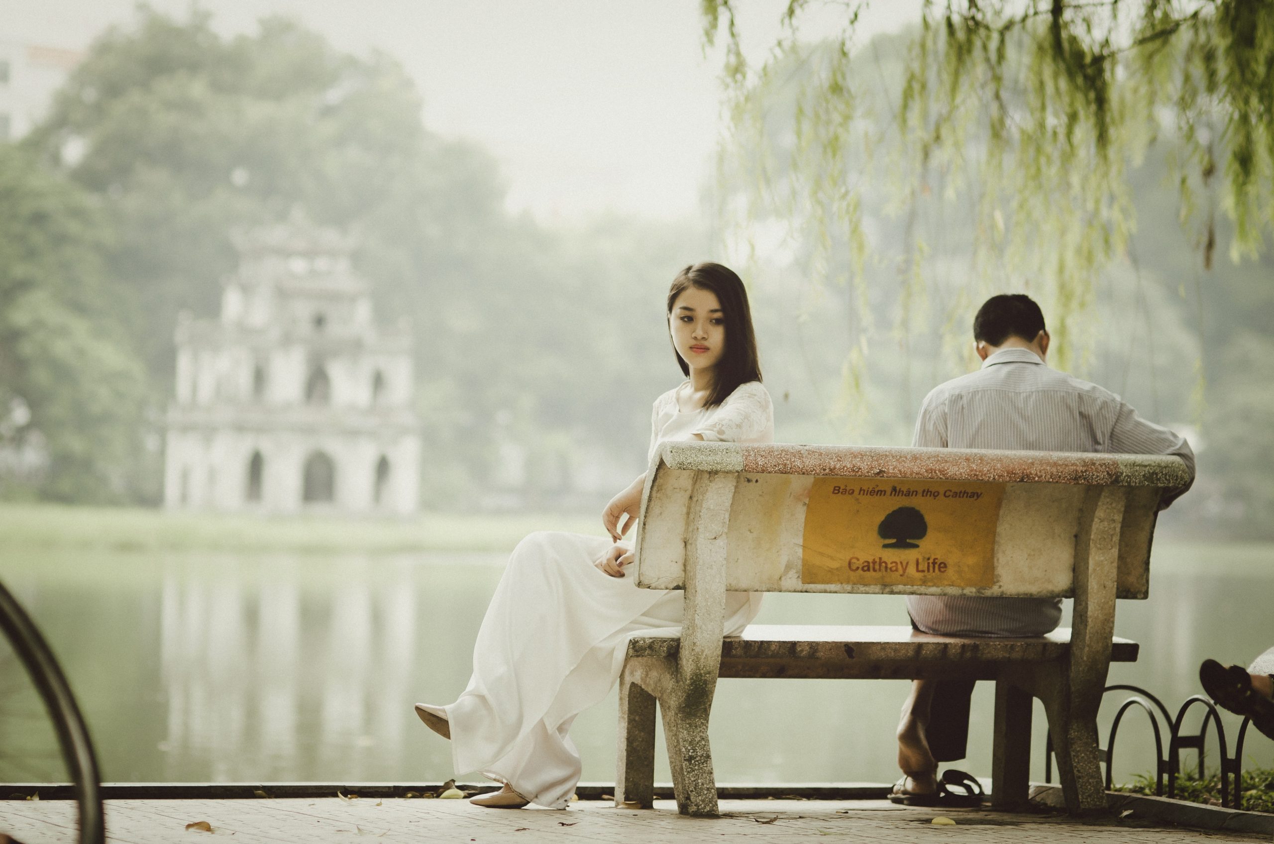 couple sitting on a bench by water