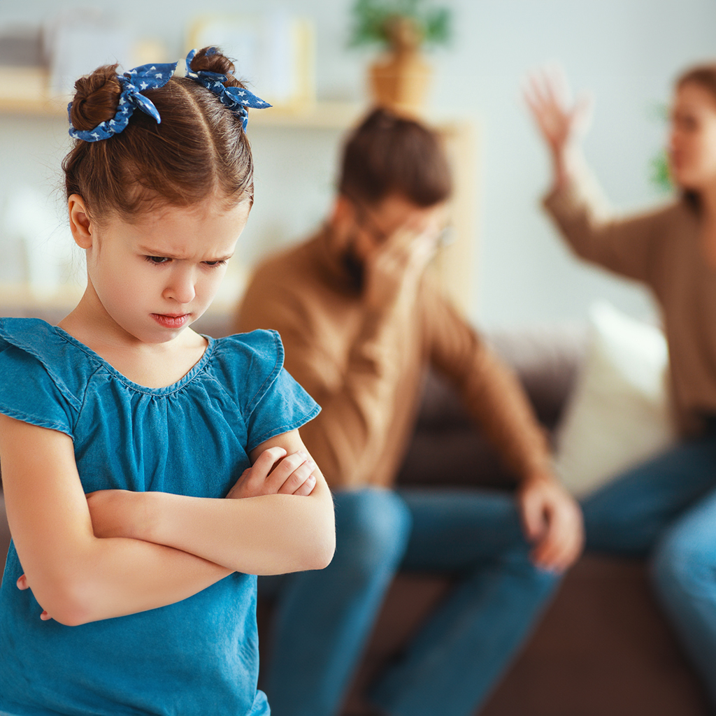 little girl that is upset because her parents are fighting in the background